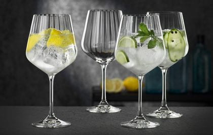 Four NACHTMANN Gin and Tonic glasses, three of them filled with different gin cocktails, one of them empty.<br/>