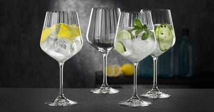 Four NACHTMANN Gin and Tonic glasses, three of them filled with different gin cocktails, one of them empty.<br/>