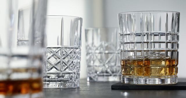 The NACHTMANN Highland tumblers in different cut patterns, the tumbler with the Square pattern filled with whisky on the rocks.<br/>
