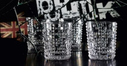 Deux gobelets à whisky NACHTMANN Punk sur une table noire devant un miroir brisé avec le mot écrit punk et un junion jack dans ce miroir.<br/>