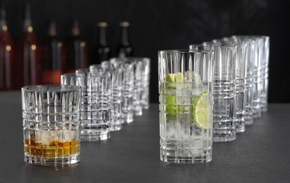 NACHTMANN Highland Square Becher und Longdrinkgläser in einer Reihe hintereinander aufgereiht. Der Becher vorne ist mit Whiskey auf Eis gefüllt und das Longdrinkglas davor mit einem klaren Drink mit Limettenscheiben und Eiswürfeln.<br/>