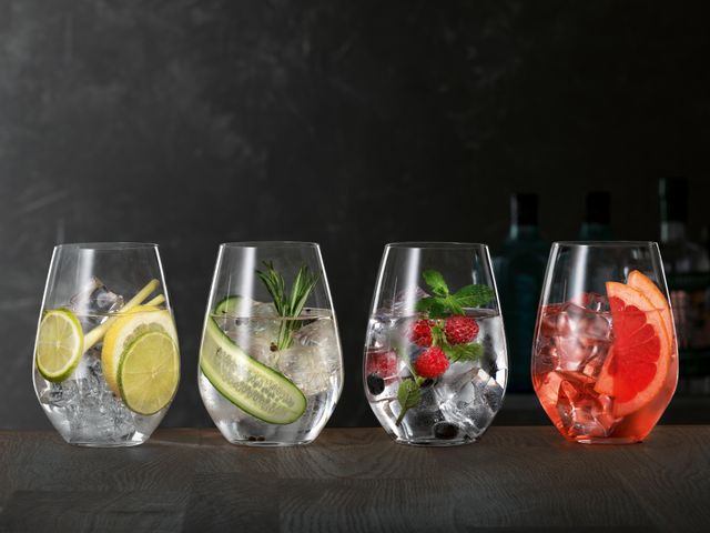 SPIEGELAU Gin and Tonic glasses on a wooden sideboard, each of thm filled with a different Gin Cocktail.<br/>