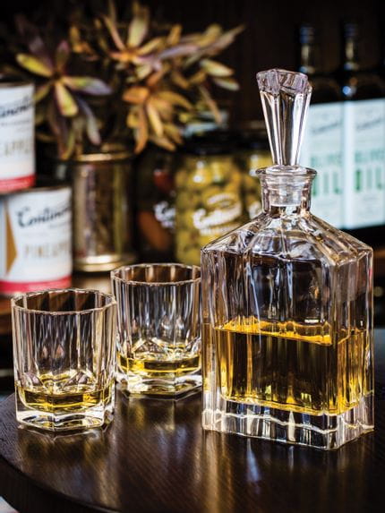 The Nachtmann Aspen Whisky Tumbler filled with whisky on a glass table top.